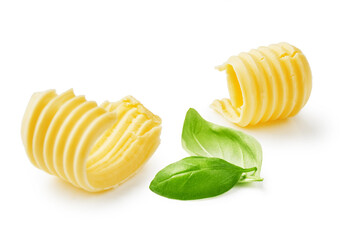 Butter curls or butter rolls with basil leaves isolated on white background