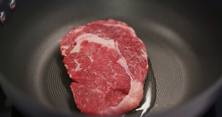 Fried steak on the pan in kitchen