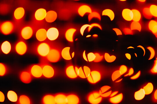 silhouette of the symbol of love - hearts against the bright orange blurred lights