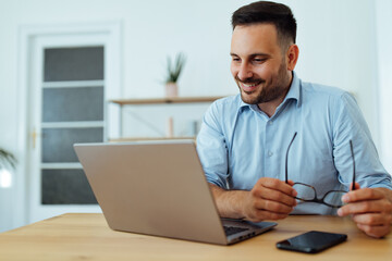 Using laptop at home office.