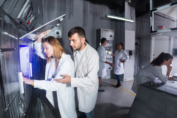 Fototapeta premium Young men and women are searching for a solution to a puzzle in a quest room laboratory