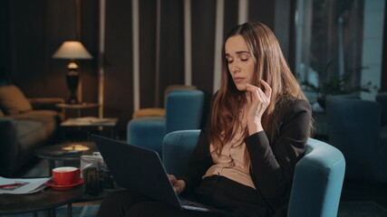 Obraz premium Tired woman working laptop computer at hotel lounge. Exhausted businesswoman