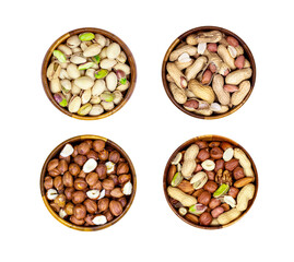 Top view of different nuts mix set: almonds, pistachios, peanuts, hazelnuts heap in round brown wooden bowl isolated on white background.