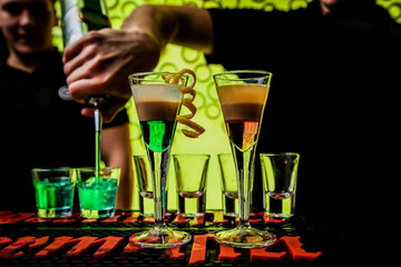 Barman preparing colorful alcoholic cocktails at the club 