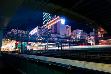 Fototapeta premium Light trail from moving train at Yokohama Station at night time. Long exposure landscape orientation.