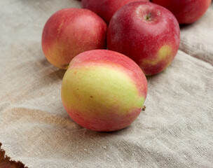 red ripe apples lies on a gray linen napkin