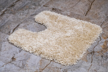 Biege mat on the floor in a bathroom