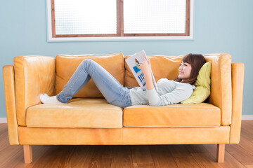 ソファで雑誌を読む女性