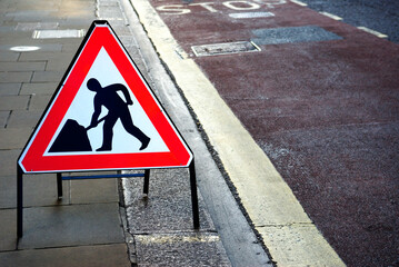 Men at work sign by side of road