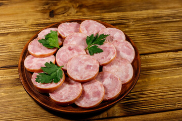 Ham sausage on a plate on wooden table