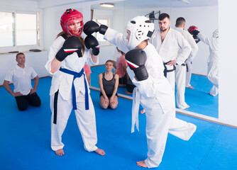 Sports girls learn how to correctly strike sparring in teaching taekwondo