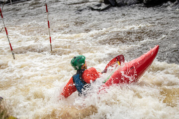 Guy in kayak sails mountain river. Whitewater kayaking, extreme sport rafting. Ireland. Europe