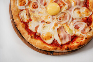 Italian pizza with egg, ham and basil on a white background close-up. Copyspace.