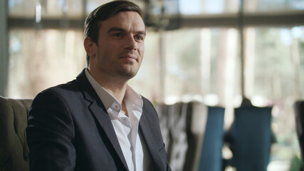 Naklejka premium Businessman calling waiter at restaurant. Handsome man gesturing hand at cafe