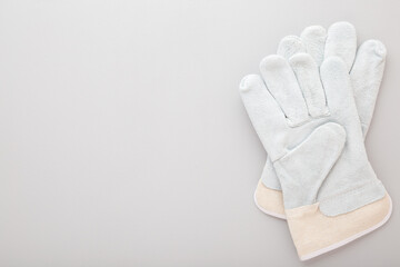 Two protective work gloves on light gray table background. Closeup. Empty place for text or logo. Top down view.