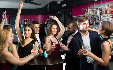 Young friends dancing on celebratory party with cocktails