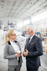 Obraz premium Man and woman discussing work. Colleagues working in factory.