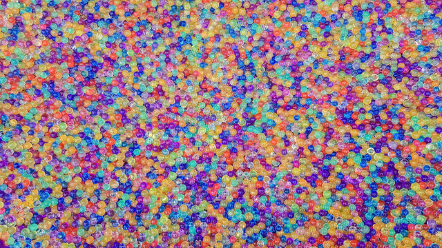 Lots of different colored hydrogel balls. Set of multicolored orbis. Crystal water beads for games. Helium balloons. Can be used as a background. Polymer gel Silica gel.