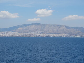 Seascape and cityscape from a moving vessel in the Mediterranean Sea.  Ferry is approaching port of Athens, Piraeus, in Greece main land.