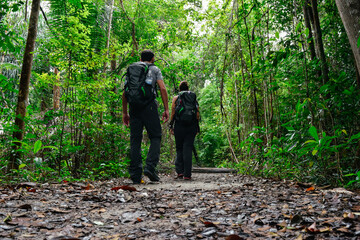 Young backpacker couple walking in forest