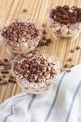 Tiramisu dessert in a glass cup on wooden table