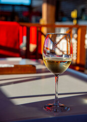A glass of white wine on the bar on a bright abstract background.
