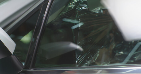 Obraz premium Bearded mechanic spraying tinted window