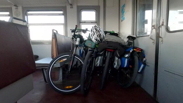 Armenia,08.20.2020 Bicycles inside passenger train՛s cabin. Four bicycles with bike bags inside old, travelling railway train. Interior of a passenger,soviet style train. Adventure travel.