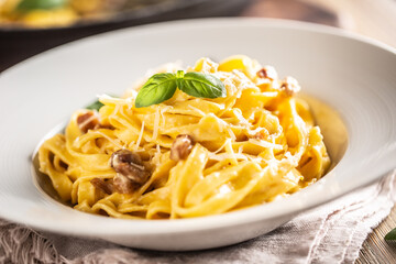 Italian food pasta tagliatelle carbonara with pancetta parmesan egg yolk and basil leaves