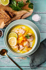 Top view of delicious and healthy salmon soup with plant-based cream, carrots and potato