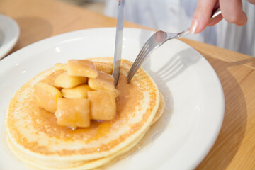 カフェでパンケーキを食べる女性