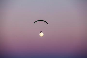 Paragliding in the night with full moon