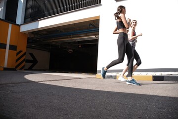 Fototapeta premium Fit women in sport clothing jogging outdoors and living a healthy lifestyle.