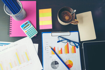 Office laptop business financial document chart and graph on wooden table with coffee cup. Flat lay notebook computer laptop on office desk. No people business graph chart mockup on business workspace