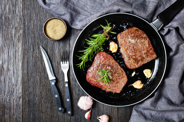 fried beef steaks on a skillet, top view