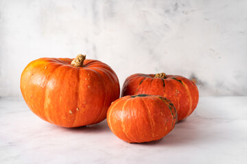 Three orange pumpkins with different size on white background