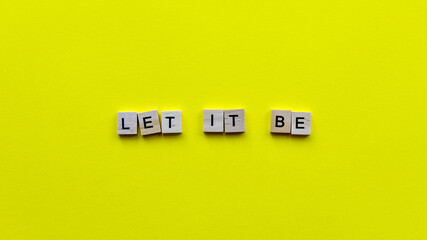 Words "Let it be" on a yellow paper background. Motivating web banner.