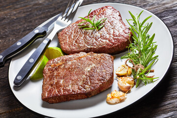 fried beef steaks on a plate, top view