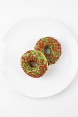 Pączki z nadzieniem i polewą na białym talerzu. Zachęcająca koncepcja na jasnym tle.