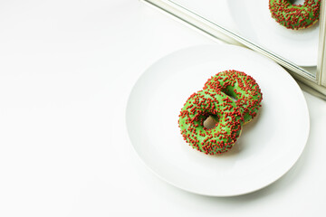 Pączki z nadzieniem i polewą na białym talerzu. Zachęcająca koncepcja na jasnym tle.