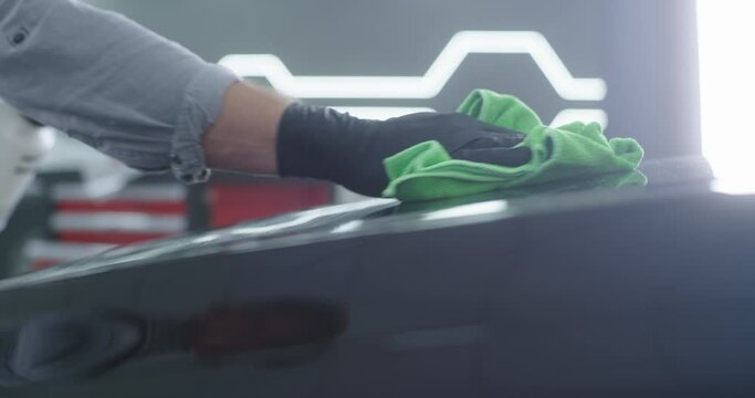 Crop mechanic cleaning car hood