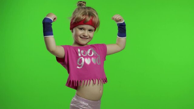 Athletic girl in pink sportswear showing muscles isolated over green screen, chroma key background