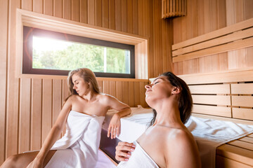 Two young women relaxing in the sauna