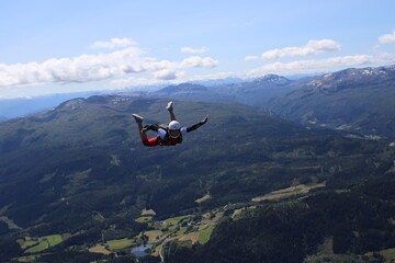 Fototapeta na wymiar Skydivers over snowy mountains in Norway