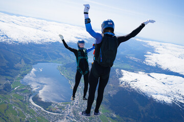 Skydivers over snowy mountains in Norway