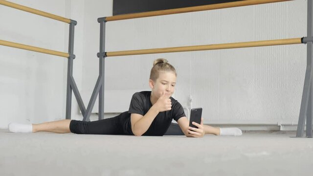 A handsome young guy is engaged in yoga and communicates online via video communication. The concept of sports and meditation. Stretching and yoga workout.