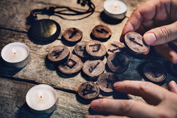 Hand holding wooden runes, esoteric and spirituality, reading and fortuneteller