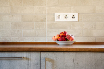 A plate with Saturn peaches on a wooden table in the kitchen. Peaches on a kitchen table against a...