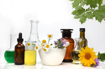 Composition with natural cosmetics and chamomile flowers on white background.