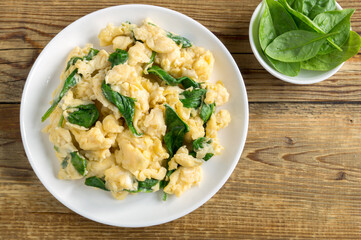 scrambled eggs with spinach in a white plate